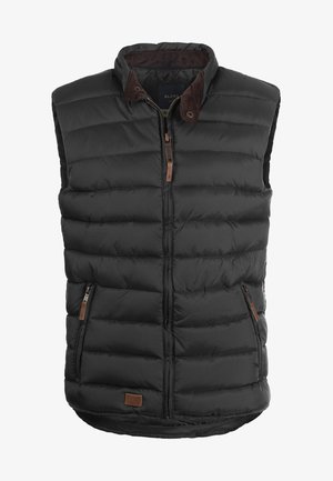 Zwarte puffer vest met hoge kraag, ritssluiting aan de voorkant en twee zijzakken. Heeft bruine accenten en een horizontale quiltstructuur.