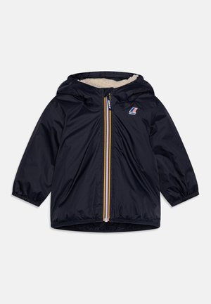 Giacca blu navy con cappuccio, caratterizzata da una cerniera frontale gialla e blu e una morbida fodera crema. Maniche lunghe con polsini elasticizzati.