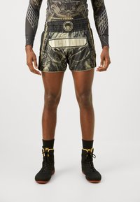 Black and gold patterned athletic shorts with an elastic waistband and logo accents, paired with black high-top athletic shoes and socks.