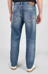 Blauwe denim jeans met een relaxte pasvorm, zichtbare stiksels, twee achterzakken en een leren merkpatch op de taille. Eenvoudige, gladde textuur.