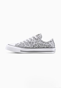 Zapatilla de lona gris con un patrón de estampado de leopardo, puntera de goma blanca y suela a rayas negras. Diseño clásico de cordones con ojetes.
