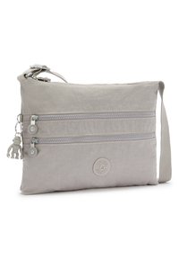 Lys grå crossbody taske lavet af nylon, med to lynlåslommer, en abe nøgleanhænger og et rundt logo patch på fronten.