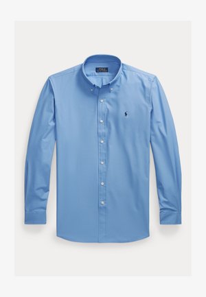 Cămașă bleu cu mâneci lungi, cu nasturi, cu guler clasic, având un mic logo închis la culoare pe pieptul stâng și nasturi albi.