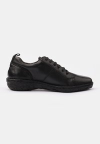 Black leather sneaker with a round toe, flat lace-up design, textured rubber sole, and stitched detailing on the sides.