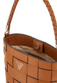Borsa a tracolla intrecciata marrone con manico intrecciato, dettagli in oro e logo. Interno con una fodera liscia che mostra il nome del marchio.