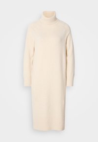 Longue robe en tricot couleur crème avec col roulé, manches longues et coupe droite simple.