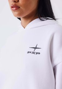 Witte hoodie van katoen, met een capuchon met trekkoord. Zwart geborduurd logo "PXP" met een sterdetail op de borst.