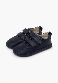 Zapatillas deportivas negras de material sintético con dos correas de Velcro, punteras redondeadas y suelas de goma texturizadas.