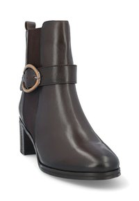 Bota de tobillo de cuero marrón con un acabado suave, punta afilada y una correa decorativa con una hebilla metálica redonda, que cuenta con paneles laterales elásticos.