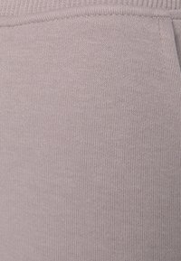 Licht mauve stof met een zachte, gestructureerde brei-design, met een subtiele stretch en een gladde afwerking. Geschikt voor casual kleding.