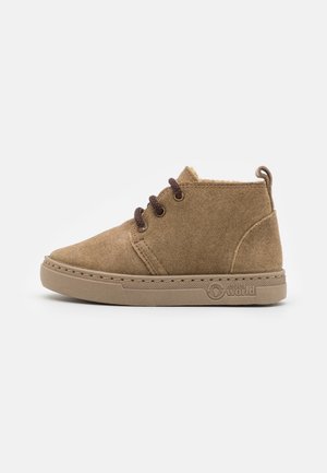 Brązowy zamszowy sneaker typu high-top z beżową podeszwą, trzema dziurkami na sznurówki i logo "natural world" po boku.