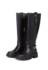 Bottes noires jusqu'aux genoux en cuir synthétique lisse, dotées d'une fermeture éclair sur le côté, d'une semelle épaisse et d'une sangle décorative avec une boucle.