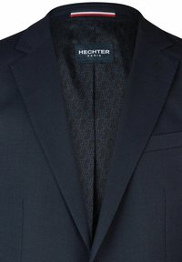 Marineblazer aus strukturiertem Material, mit einem gemusterten schwarzen Futter und einem Etikett mit der Aufschrift "HECHTER PARIS." Beinhaltet eine Brusttasche.