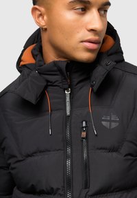 Schwarze gepolsterte Jacke mit einer orangefarbenen gefütterten Kapuze, ausgestattet mit einem Frontreißverschluss und Logo, Reißverschluss-Taschen und kontrastierenden Kordeln.