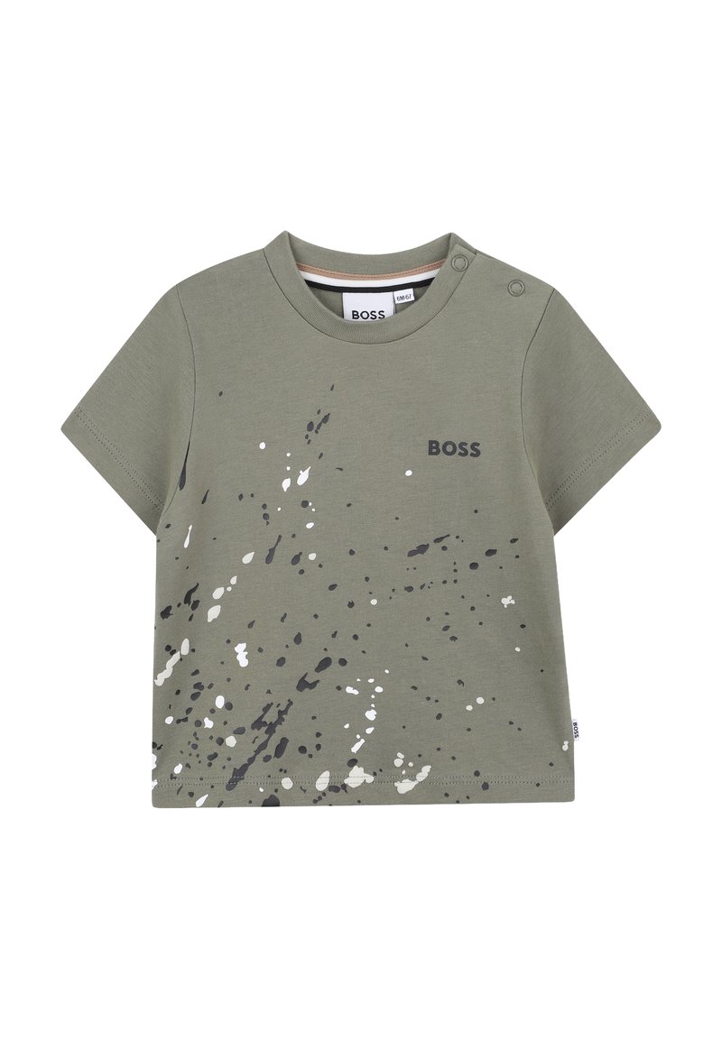 T-shirt verde a maniche corte in morbido cotone con stampa a spruzzi in grigio e bianco. Presenta un girocollo e dettagli con bottoni a pressione sulla spalla.
