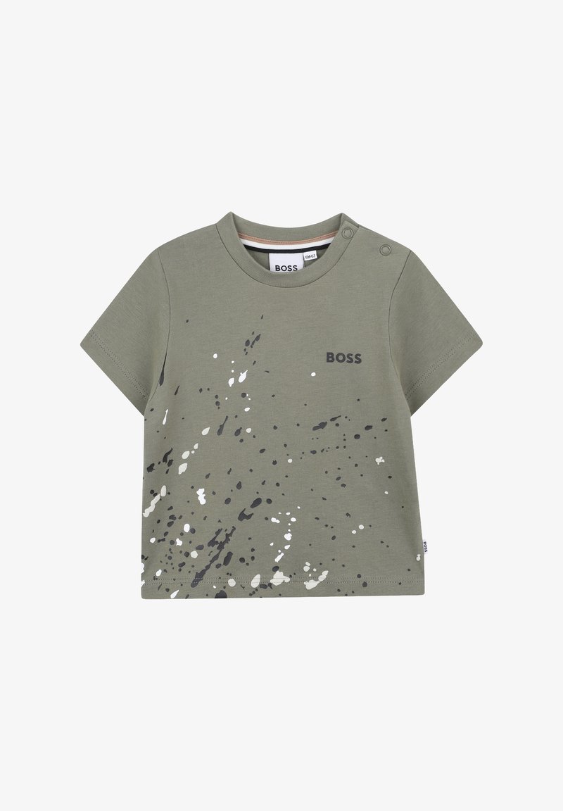 T-shirt verde a maniche corte in morbido cotone con stampa a spruzzi in grigio e bianco. Presenta un girocollo e dettagli con bottoni a pressione sulla spalla.