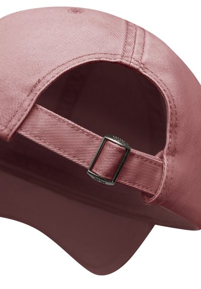 Close-up van een poederroze baseballpet met een verstelbare stoffen riem en metalen gesp aan de achterkant.