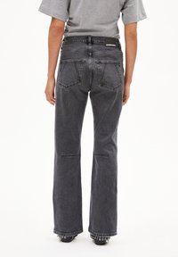 Hoge taille zwarte denim jeans met een flared pijp, voorzien van twee achterzakken en stiksels langs de naden.