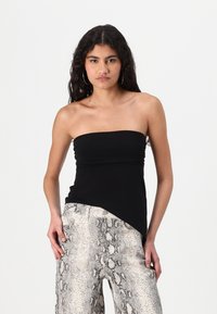 Sort strapless top med rynke-detaljer, parret med lysegrå bukser med slangeskindsprint og bred benvidde, der har en tekstureret finish.
