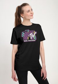 Černé tričko s barevným logem MTV a vzorem šachovnice. Motiv zahrnuje světle modré akcenty a slova "MUSIC TELEVISION."