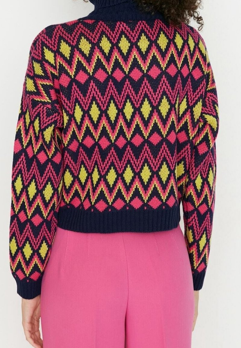 Sweter dziany z geometrycznym wzorem w różowe, żółte i granatowe kolory, z wysokim kołnierzem i prążkowanym obszyciem. Krótkie krojenie z teksturowaną tkaniną.