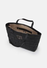 Zwarte geweven handtas met twee stevige handgrepen, voorzien van een goudkleurig logo accent en een beige gevoerde binnenkant met zakken en een ritsluiting.