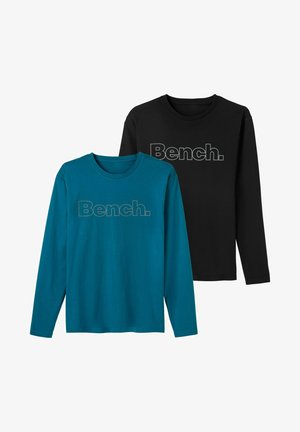 Two long-sleeve t-shirts: one in teal with a gray “Bench.” logo, and one in black with a gray “Bench.” logo. Cotton material, crew neck.