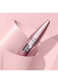 Mascara Maybelline Lash Sensational in un elegante tubo metallico rosa, con testo nero e un design affusolato, appoggiato su uno sfondo rosa chiaro.