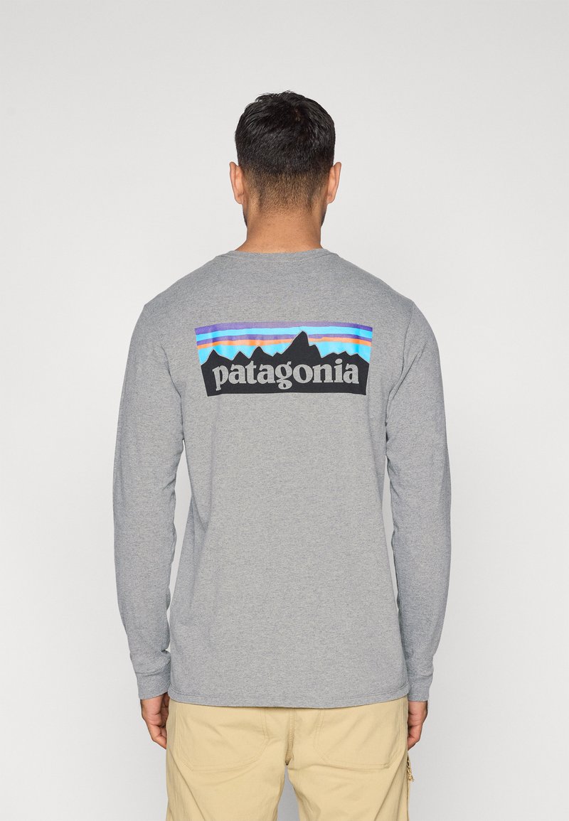 Γκρι μακρυμάνικη μπλούζα με πολύχρωφο γραφικό βουνού και το κείμενο "patagonia" στην πλάτη. Μαλακό ύφασμα, άνετη εφαρμογή.