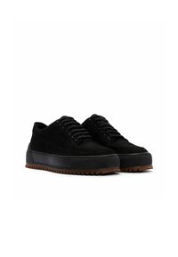 Sneaker in suede nera con suola in gomma spessa dai bordi seghettati, lacci rotondi e design a taglio basso.