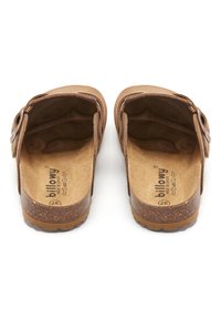 Sandales à enfiler en daim brun avec une semelle en liège texturée et une sangle ajustable, présentant un intérieur lisse et un logo embossé sur la semelle.