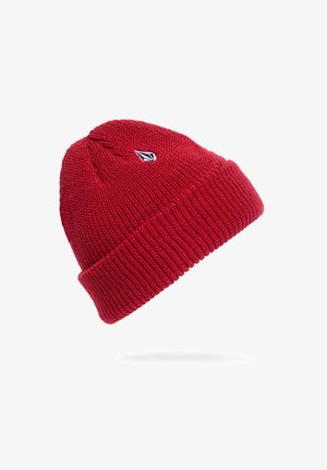 Gorro de punto rojo con vuelta, que presenta un pequeño logo en blanco y negro. La textura es acanalada, proporcionando calidez y elasticidad.