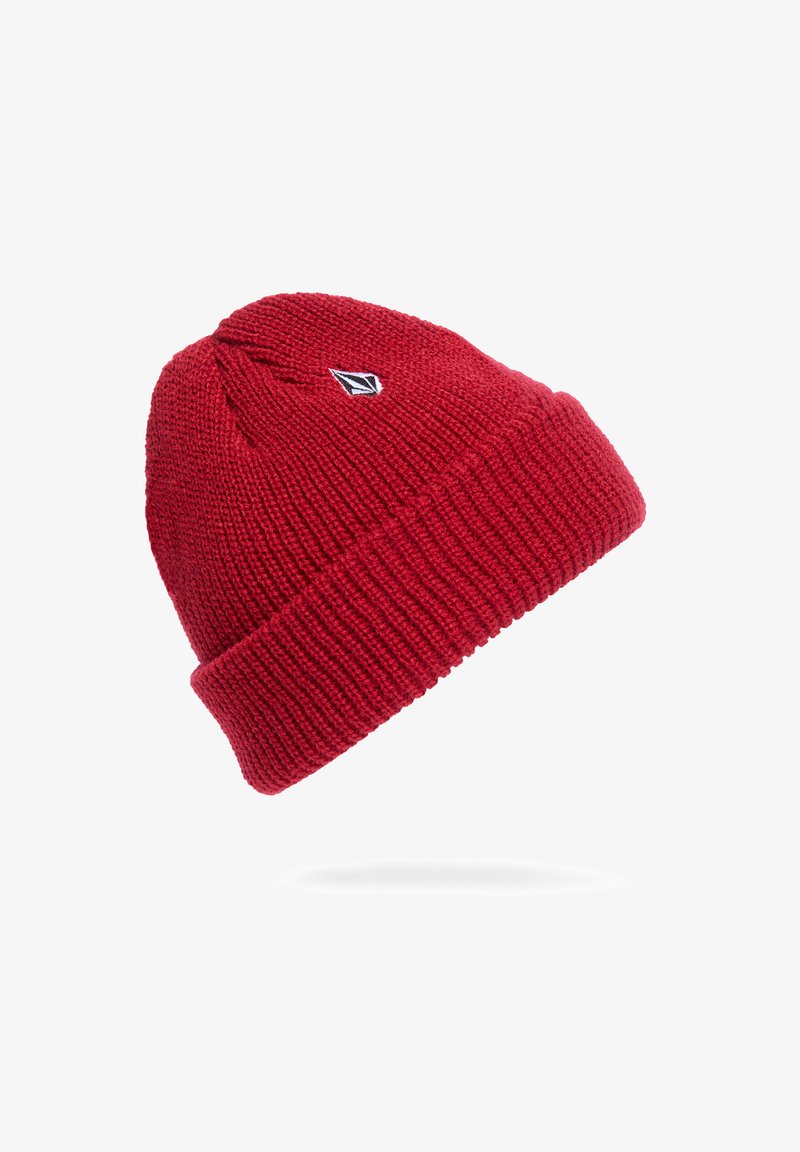 Red knitted beanie with a folded cuff, featuring a small black and white logo. The texture is ribbed, providing warmth and stretch.