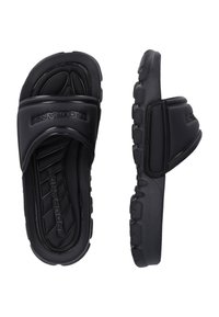 Black slide sandals made of rubber, featuring a wide upper strap, textured footbed, and a thick, patterned sole for traction.