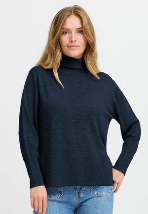 Swaeter turtleneck lengan panjang berwarna biru navy dengan finishing tekstur, potongan santai, dan aksen rib di manset dan bawah.