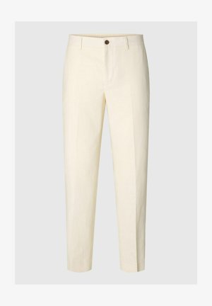 Krém színű, testre szabott nadrág elülső gombbal és övbujtatókkal, egyszínű háttér előtt bemutatva.