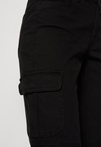 Svarta cargoshorts i slitstarkt material, med en sidoficka och kontrasterande sömmar, i en tight passform och med en mjuk textur.