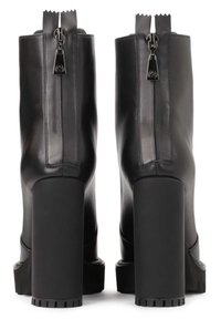 Stivali ankle in pelle nera con tacco spesso, zip texture con tirante argentato e un distintivo bordo superiore a zigzag.