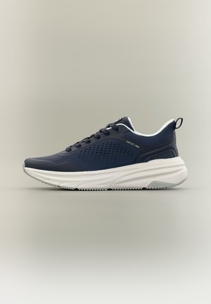 Scarpa da ginnastica sportiva blu navy con lati traforati, suola imbottita bianca, design con lacci e linguetta in tessuto su sfondo neutro.