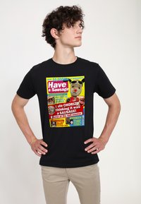 Svart bomull t-shirt med en färgglad grafik som har text och illustrationer relaterade till korvar. Framträdande designelement inkluderar tecknat liknande bilder.
