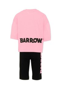 Camiseta rosa de manga corta con la palabra "BARROW" en negro en la espalda, combinada con pantalones cortos negros que tienen el texto "BARROW" en rosa en el lateral.