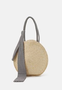 Borsa di paglia rotonda con una finitura naturale testurizzata. Presenta un manico in tessuto a righe bianche e nere e un dettaglio con fiocco.