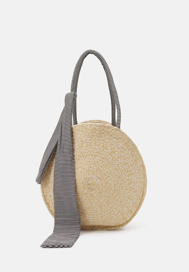 Borsa di paglia rotonda con una finitura naturale testurizzata. Presenta un manico in tessuto a righe bianche e nere e un dettaglio con fiocco.