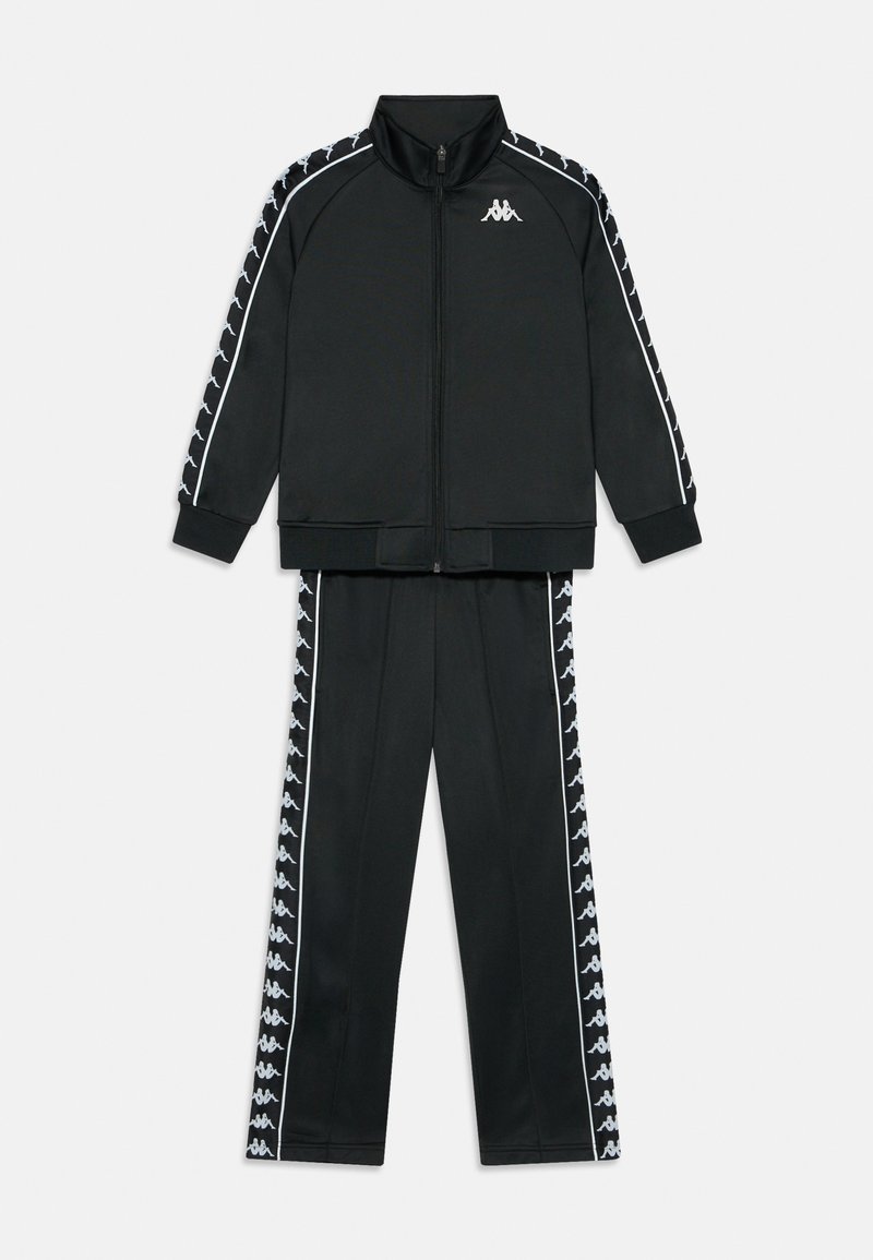 Melns poliestera treniņu uzvalks ar rāvējslēdzēju jaku, kas rotāta ar baltām akcentu svītrām, un saderīgām biksēm ar rakstainām sānu paneļiem.