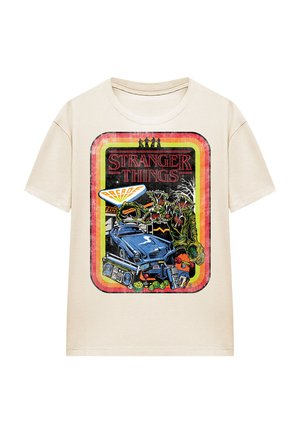 Beige cotton t-shirt featuring a colorful graphic print. Design includes a blue car, monsters, and items related to the "Stranger Things" theme.