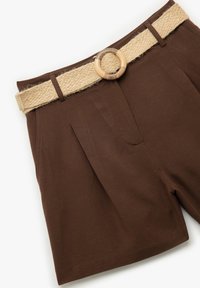 Pantaloni corti marroni realizzati in un tessuto liscio. Presentano una cintura intrecciata beige con una fibbia di legno rotonda e pieghe frontali per un tocco di dettaglio in più.
