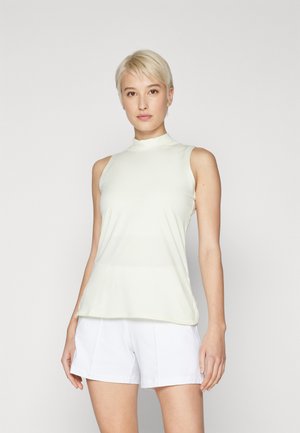 Lys gul uten ermer topp med høy hals, glatt tekstur og avslappet passform, parret med hvite shorts. Enkel, minimalistisk design.