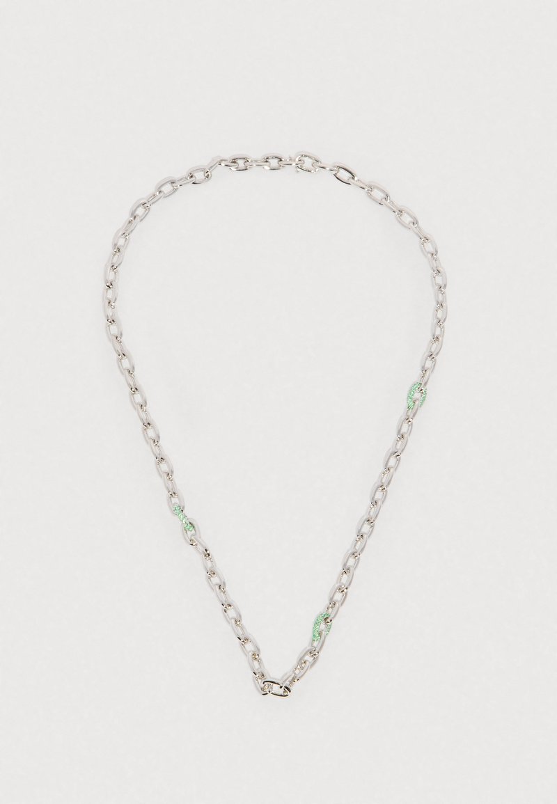 Srebrny naszyjnik łańcuchowy z owalnymi ogniwami i czterema małymi ogniwami pokrytymi zielonymi kamieniami szlachetnymi, rozmieszczonymi równomiernie wokół.