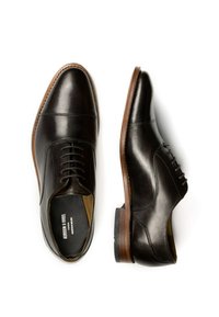 Scarpe eleganti in pelle marrone con finitura liscia, punta arrotondata, design con lacci e suola in legno a contrasto, caratterizzate da dettagli di cucitura.