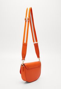 Borsa a tracolla arancione con forma curva, realizzata in materiale sintetico liscio, dotata di una tracolla in tessuto a righe e con dettagli in oro.